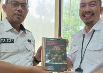 Drs. Dani Bastiani (Kepala Disbudparpora Kota Cimahi) bersama Ares Rudhiansyah, S.Pd. (Kepala Seksi Kebudayaan Kota Cimahi) mengapresiasi buku Kampung Adat Cireundeu; Warisan Budaya Leluhur.